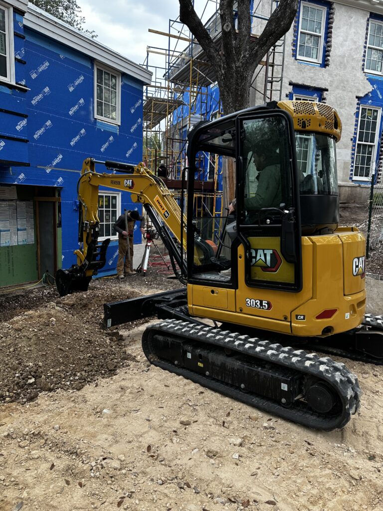Mini excavator digging site prep for a new home build in Leander, TX