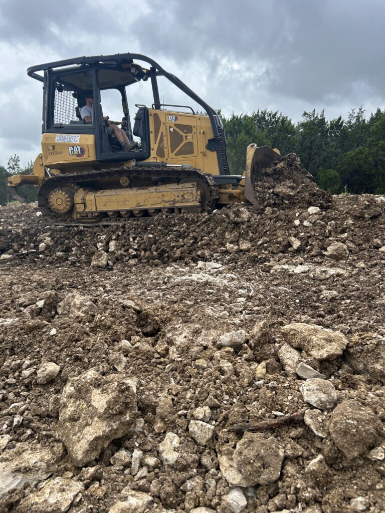 Bulldozer pushing rocky soil during large-scale land grading and site preparation work
